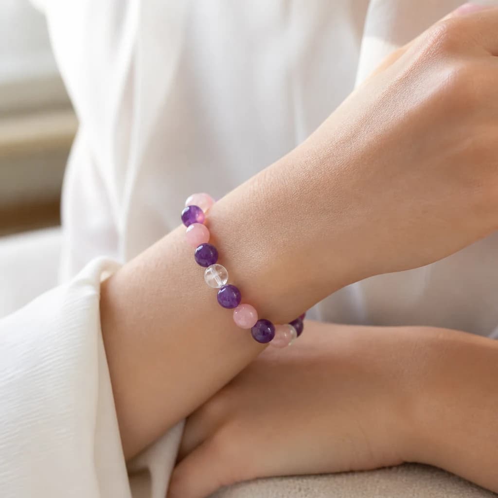 A rose quartz, amethyst and clear quartz bead bracelet on a wrist